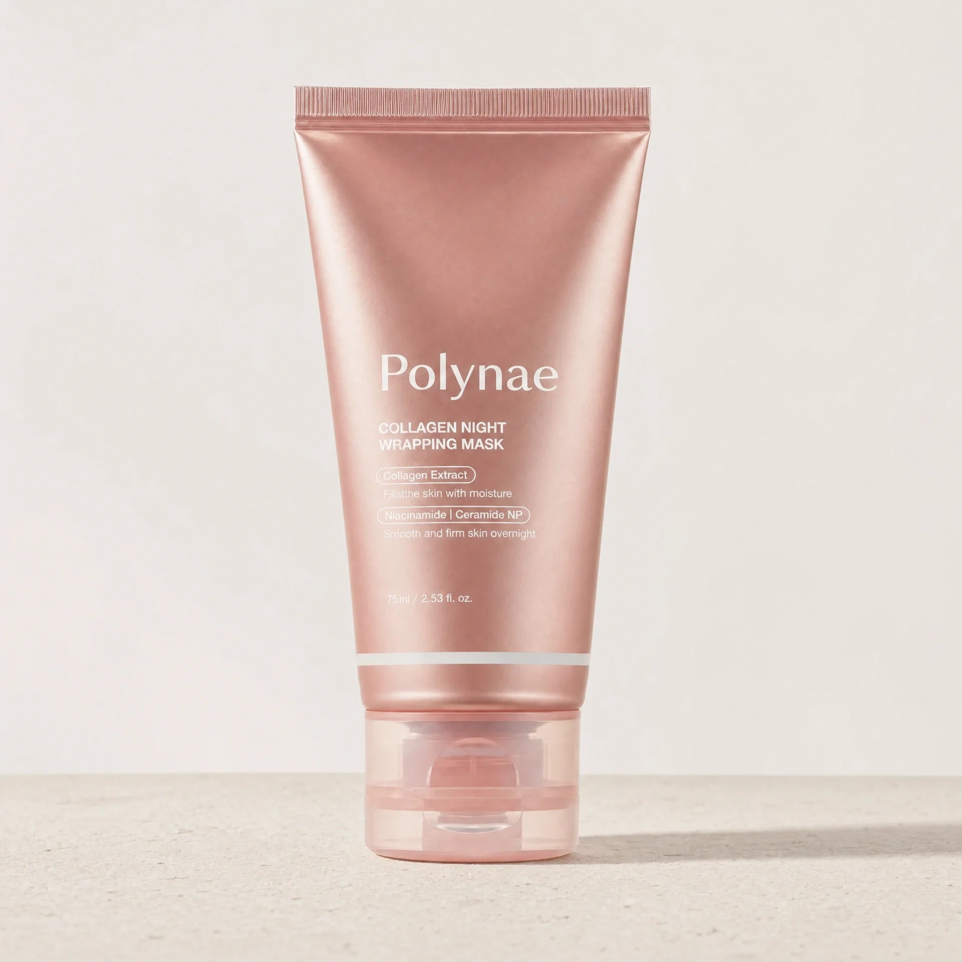 Polynae Collagen Night Wrapping Mask tube standing upright on a light stone surface against a neutral background
