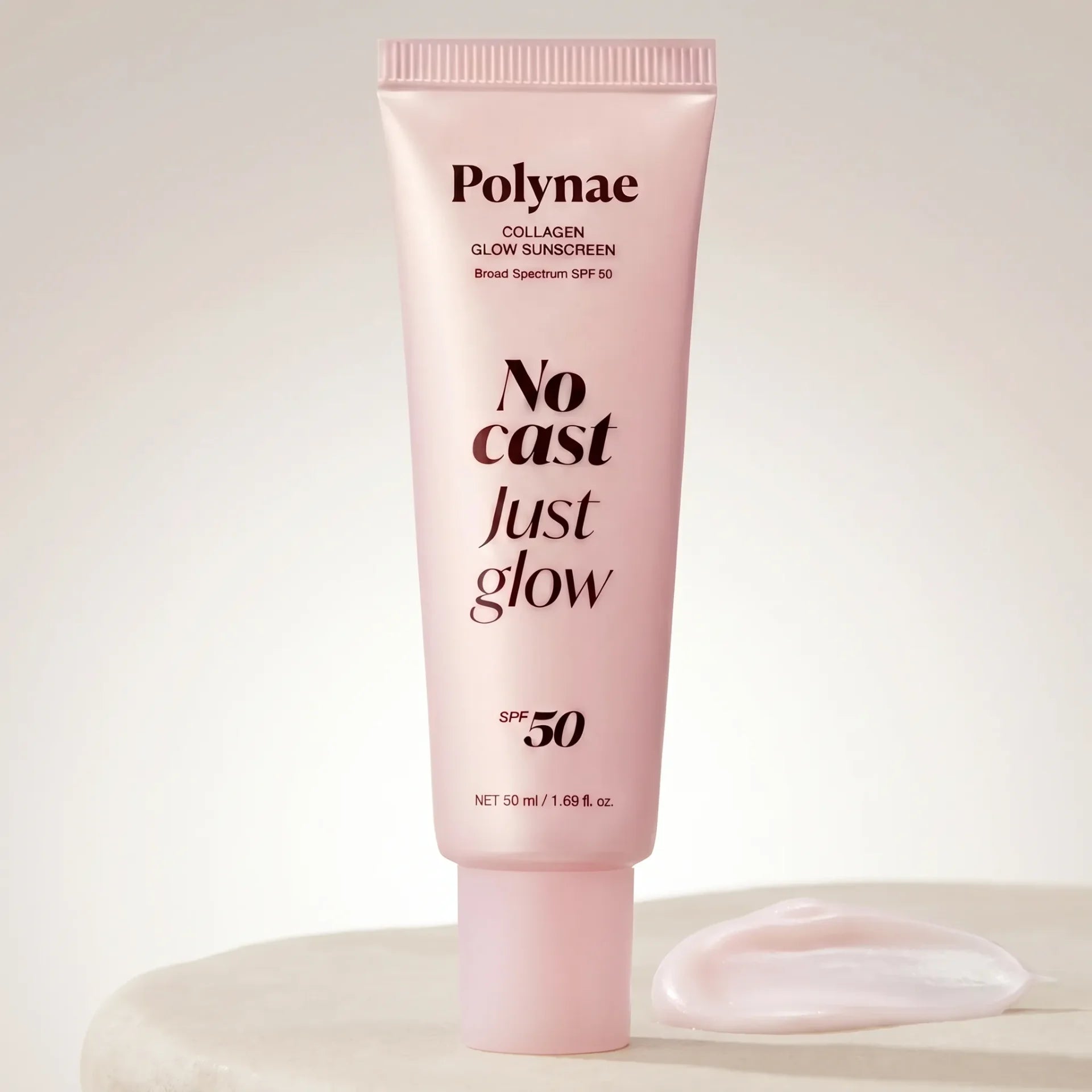 Polynae Collagen Glow Sunscreen tube in pale pink standing upright on a white surface with a cream swatch beside it