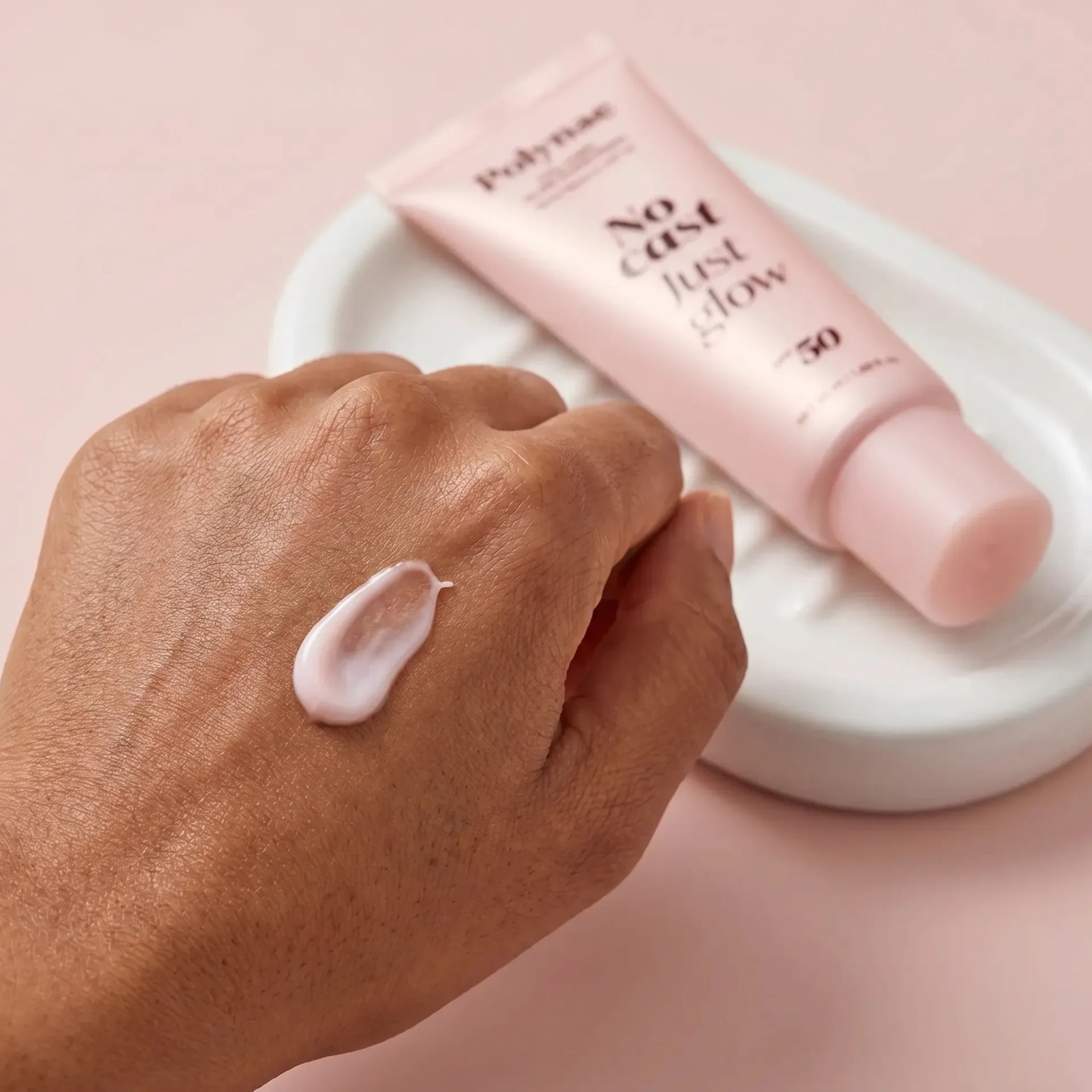 Close-up of a dark-skinned hand with a small unblended dot of Polynae sunscreen cream resting on the back of the hand