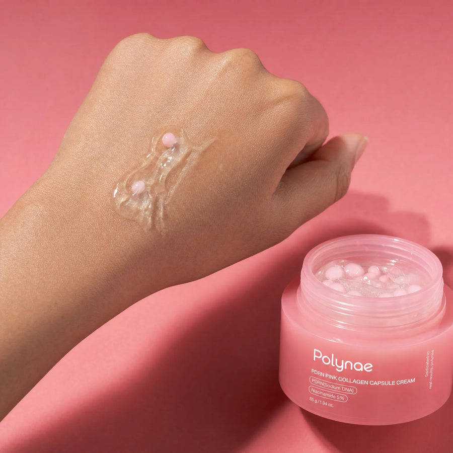 Clear gel swatch of Polynae PDRN Pink Collagen Capsule Cream applied to the back of a hand, showing two pink capsule beads sitting in the translucent product