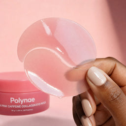 Close-up of a hand holding two translucent pink Polynae gel eye patches, showing their flexible, serum-soaked texture