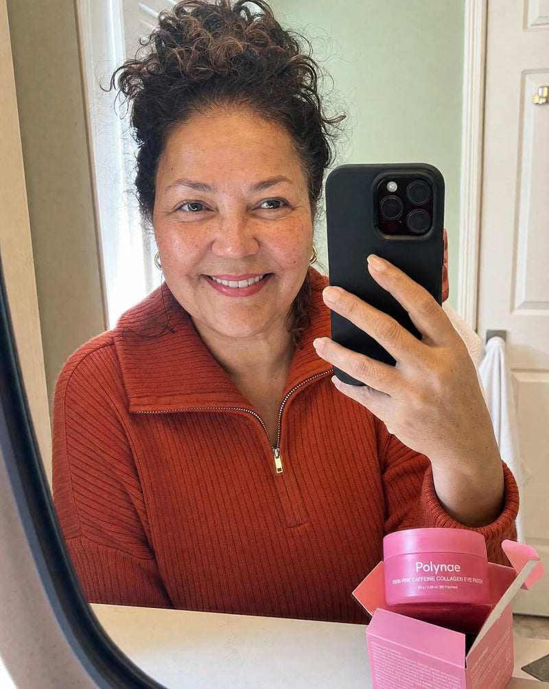 Customer taking a mirror selfie while holding the Polynae PEPN Pink Caffeine Collagen Eye Patch jar and its pink box