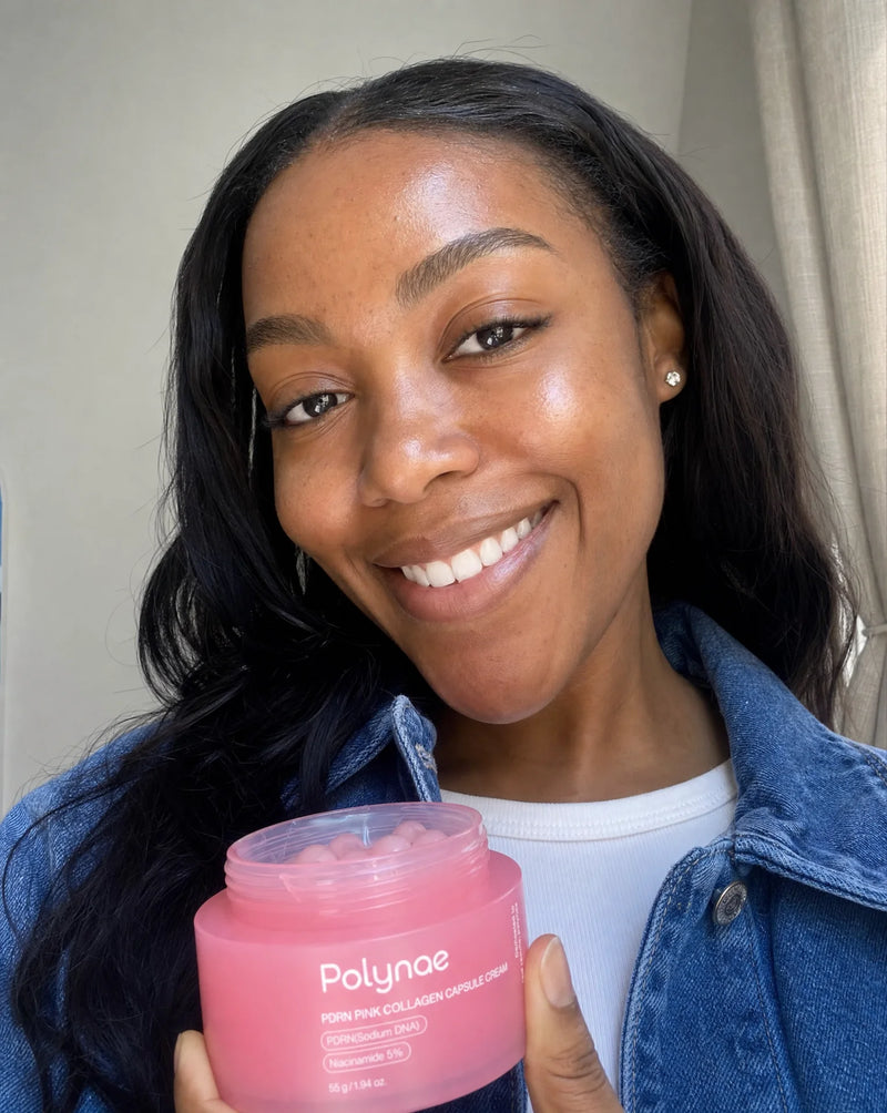 Smiling woman holding the open Polynae PDRN Pink Collagen Capsule Cream jar toward the camera